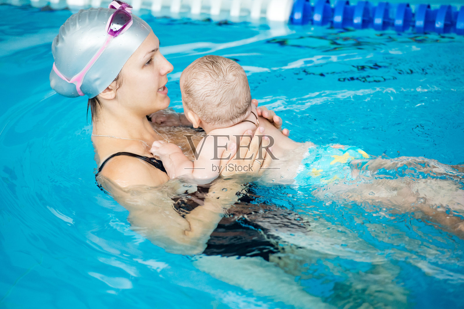 年轻美丽的母亲和她的小儿子参观游泳池照片摄影图片