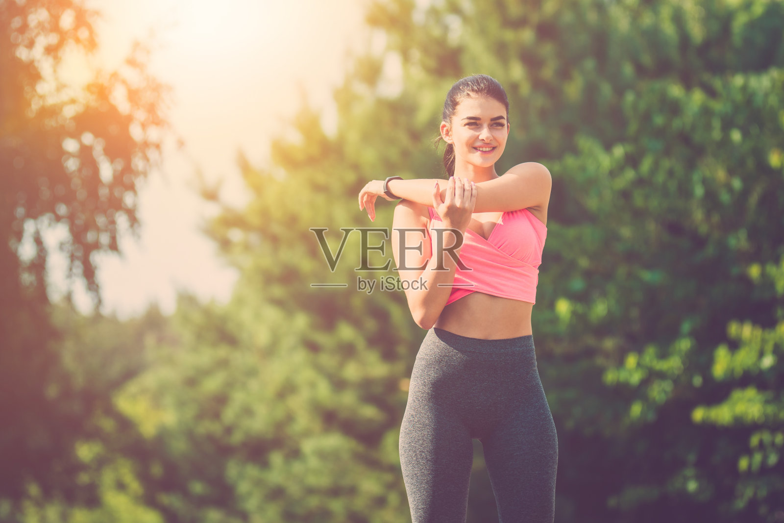 女运动员在阳光明媚的背景下做运动照片摄影图片