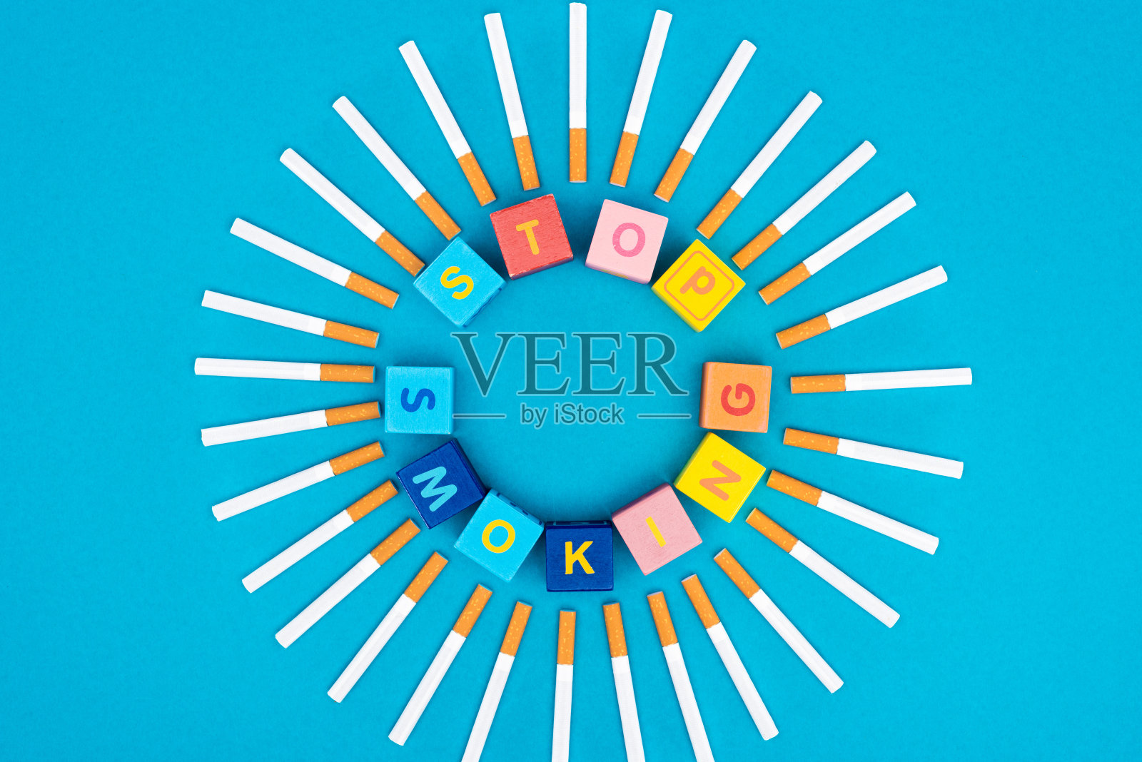 工作室拍摄的香烟和彩色立方体与字母孤立的蓝色，停止吸烟的概念照片摄影图片