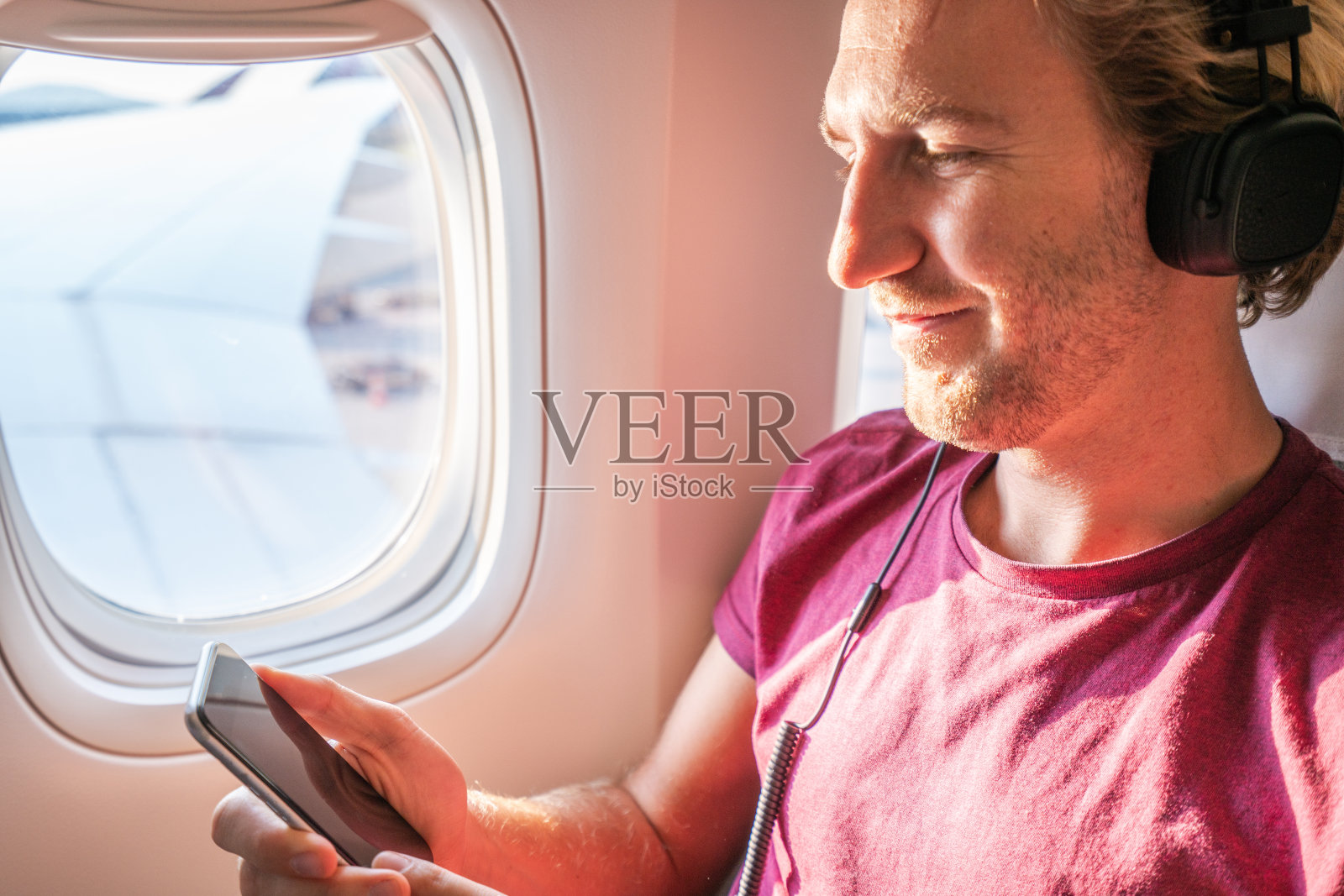 在飞机上听音乐的旅行男子照片摄影图片