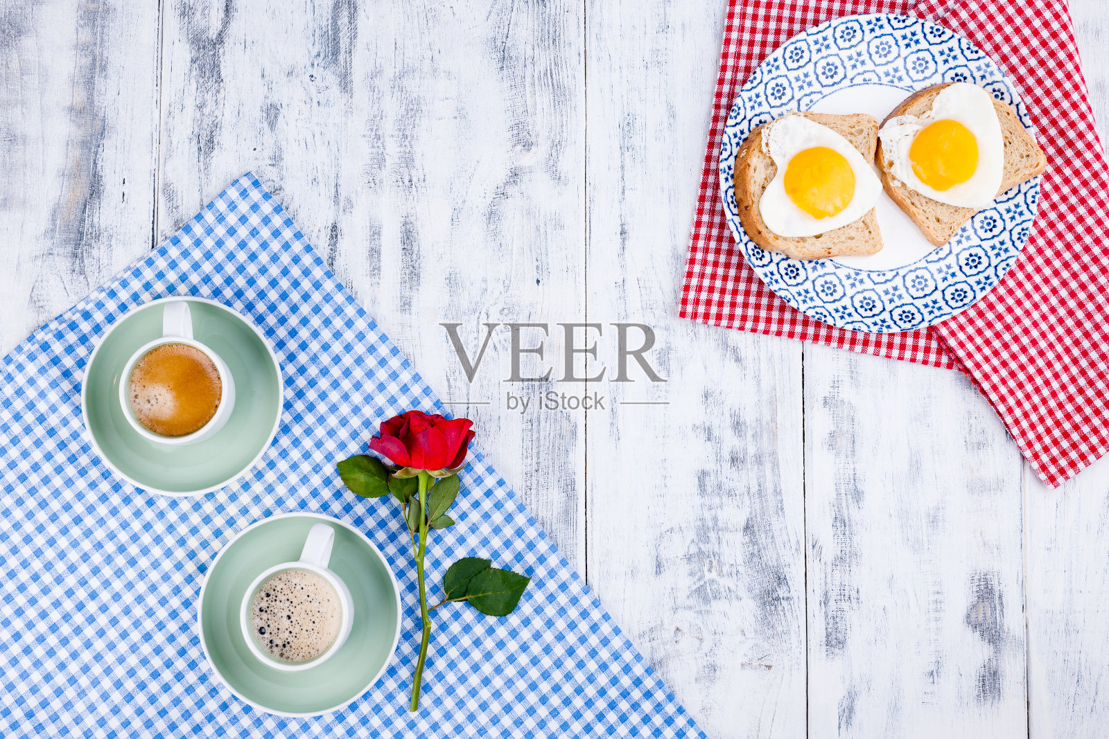 烤面包和一个心形的鸡蛋在一个盘子和两杯咖啡。浪漫的双人早餐。红玫瑰和早餐惊喜。情人节和母亲节的概念。照片摄影图片