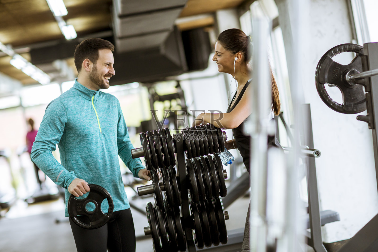 女性在私人教练的帮助下在健身房锻炼照片摄影图片