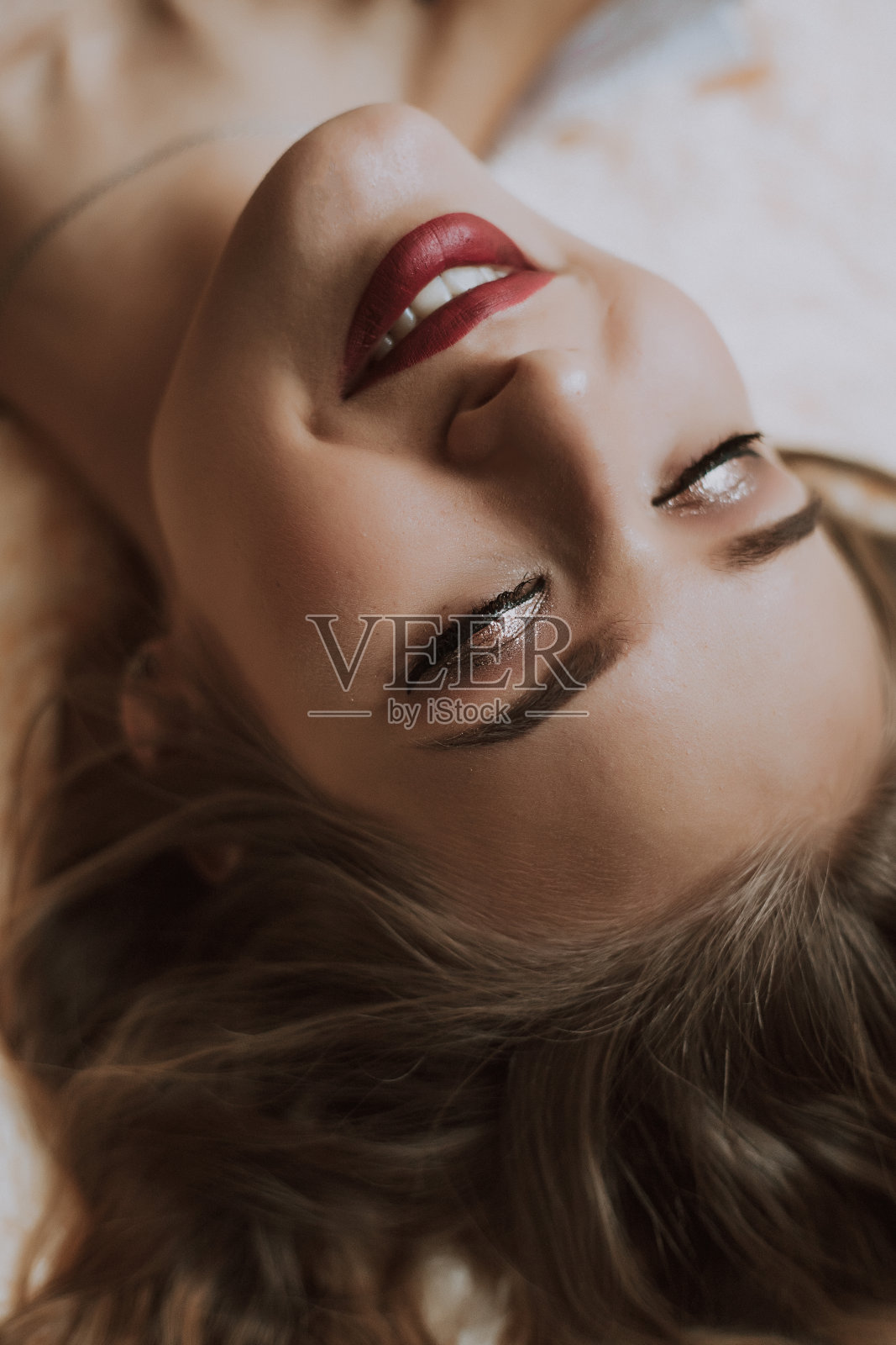 床上有个穿着白衬衫的漂亮女孩照片摄影图片