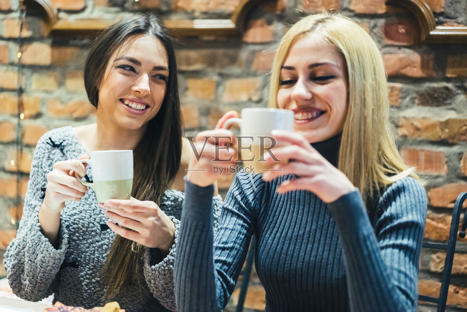 两个女孩在咖啡馆喝热饮照片摄影图片