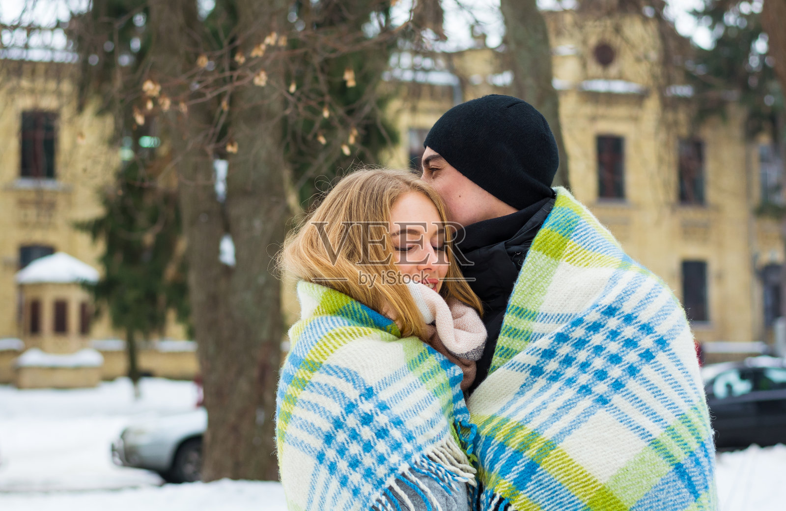 冬天里躺在毯子里的恩爱夫妻。照片摄影图片