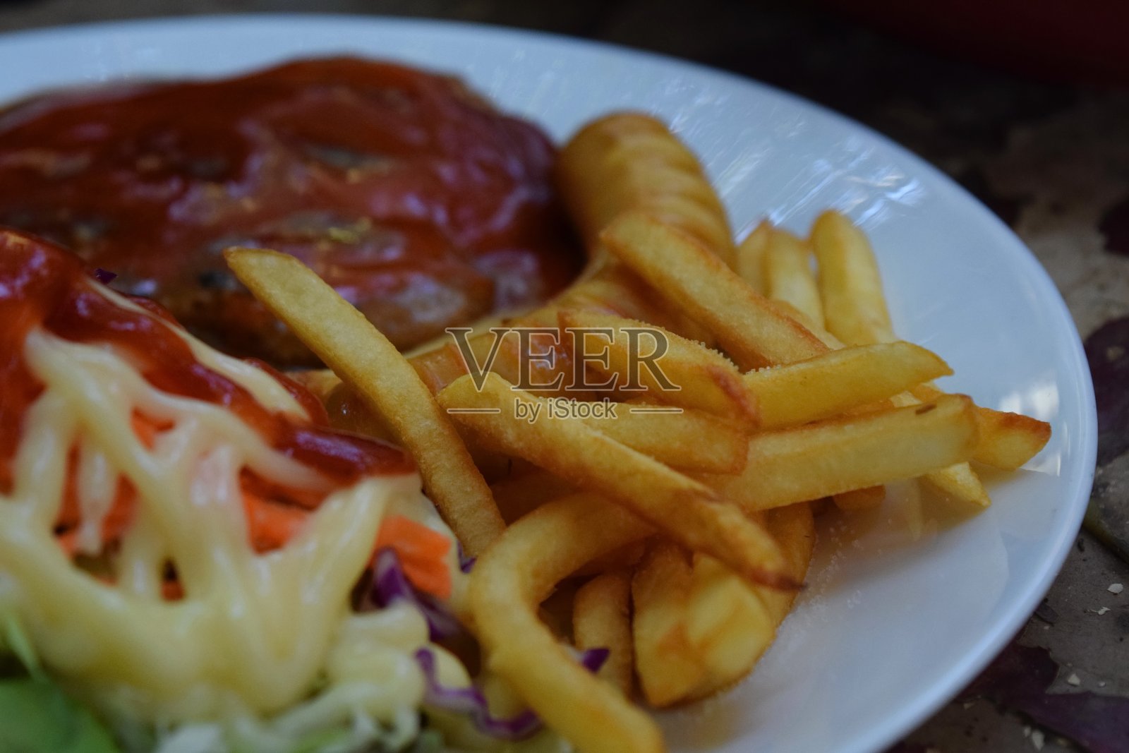 猪排配蔬菜沙拉和薯条在一个盘子里。照片摄影图片