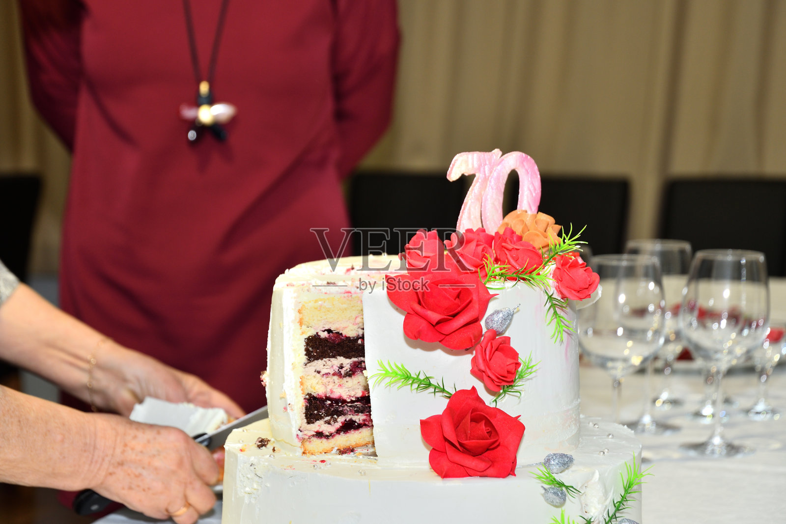 庆祝时，祖母用刀切了一块大甜蛋糕照片摄影图片