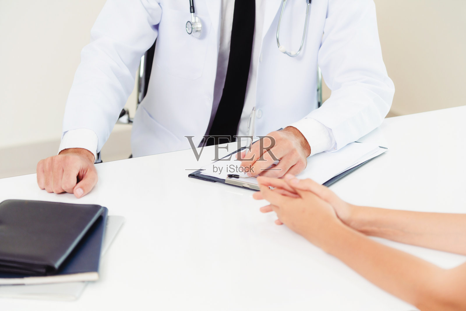 医院办公室的男医生和女病人照片摄影图片