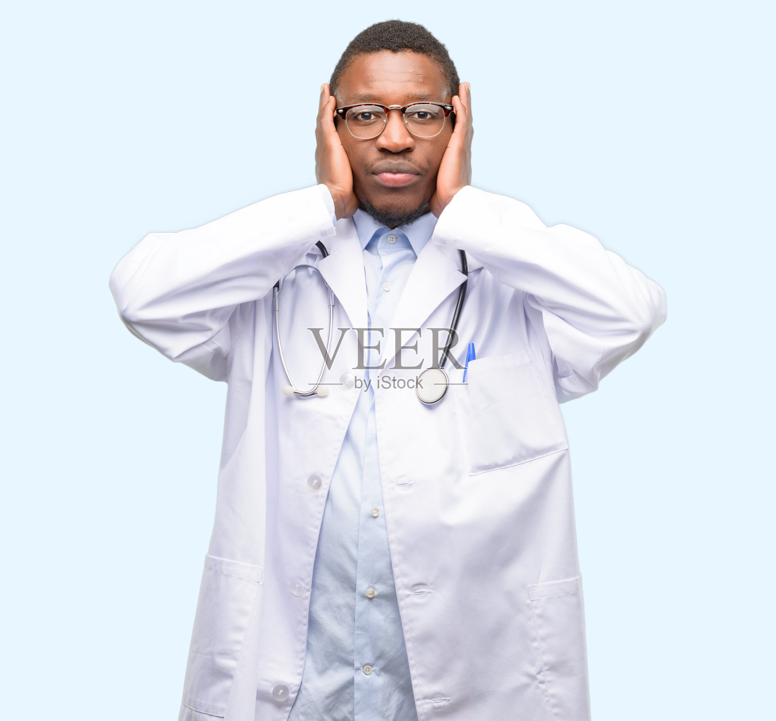 年轻的黑人医生，医学专业人士捂住耳朵不理会恼人的噪音，塞住耳朵避免听到声音。嘈杂的音乐是个问题。照片摄影图片