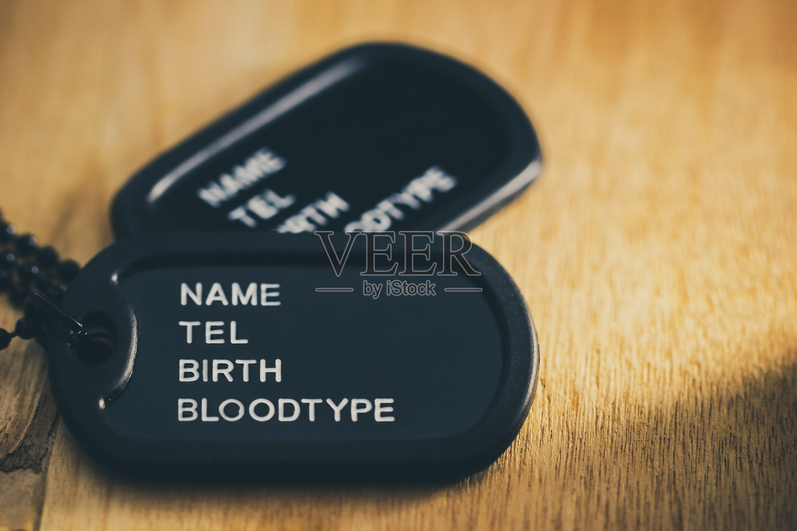 士兵牌或狗牌放在棕色的木桌上。照片摄影图片