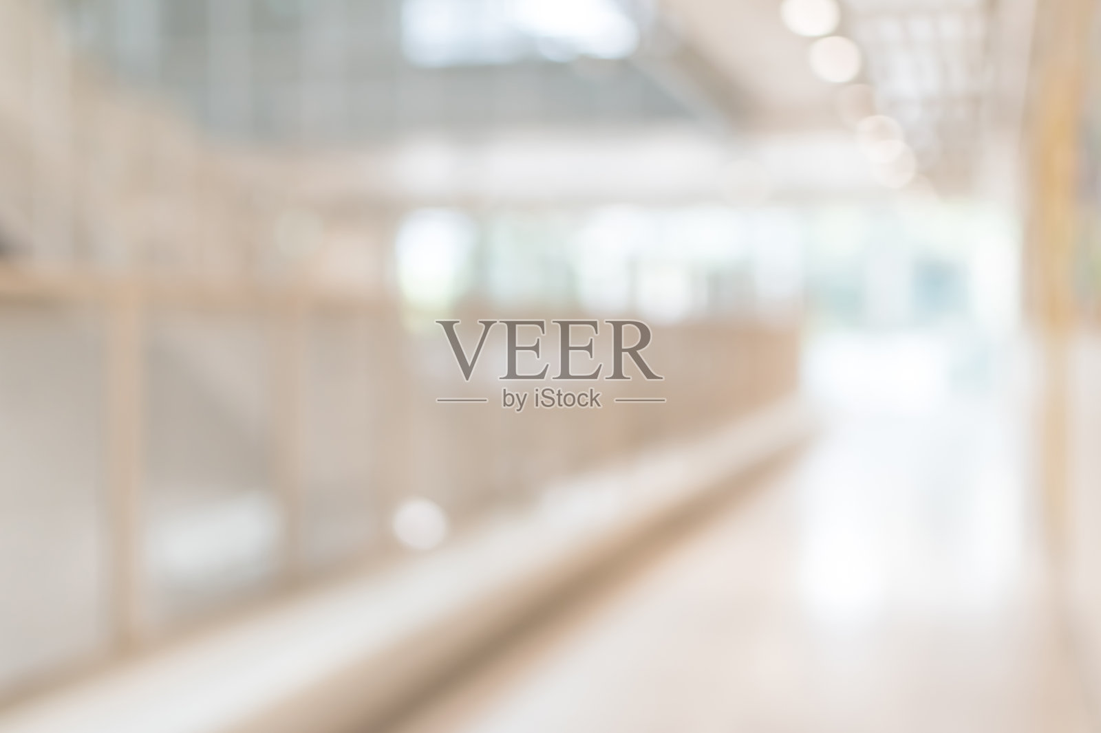 学校或办公楼的走廊背景模糊，室内视野模糊，空荡荡的走廊，玻璃幕墙和地板，外部灯光照明照片摄影图片