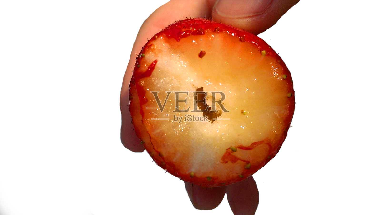 新鲜成熟的草莓手孤立在白色背景。多汁的果浆内带洞，吃后选择性聚焦。照片摄影图片