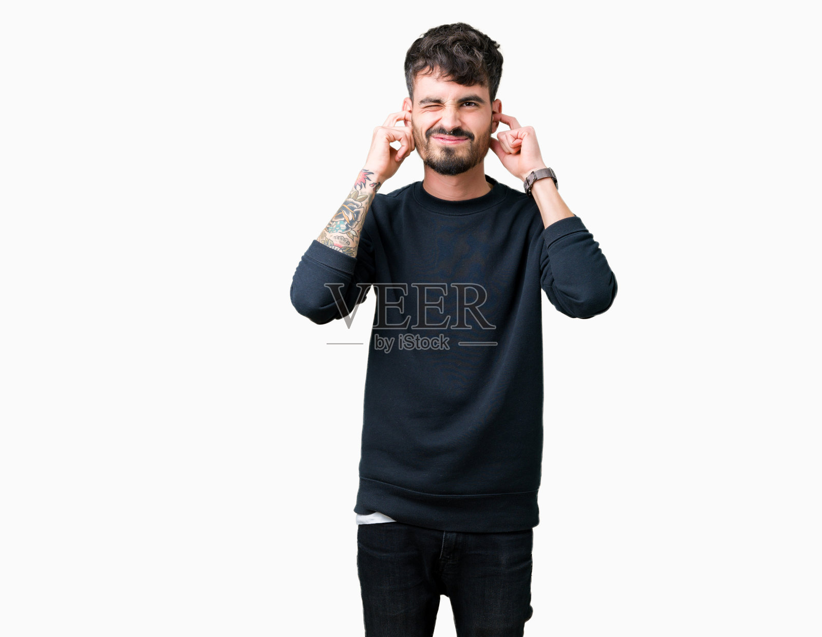 年轻英俊的男子隔着孤立的背景，用手指捂住耳朵，用恼怒的表情表示大声的音乐噪音。聋的概念。照片摄影图片