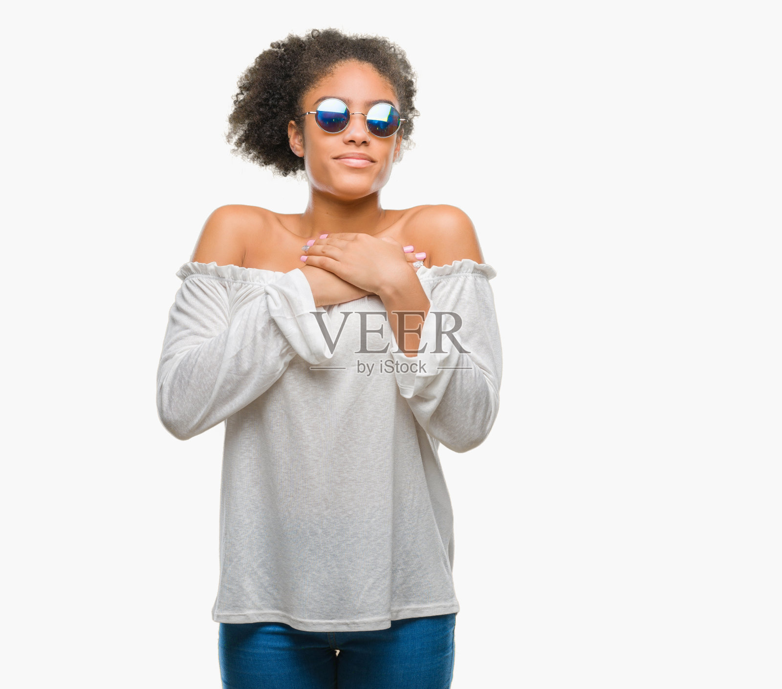 年轻的非洲裔美国妇女戴着太阳镜在孤立的背景微笑，双手放在胸前，闭上眼睛和感激的手势在脸上。健康的概念。照片摄影图片