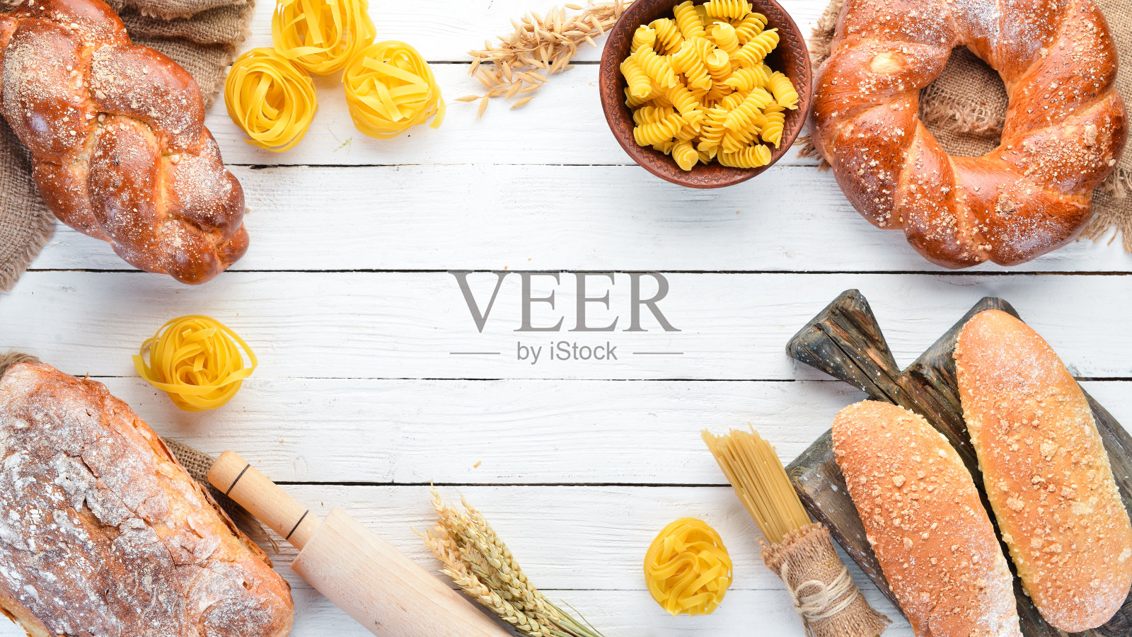 无谷蛋白食物。各种意大利面，面包，小吃和面粉在白色的木制背景。前视图。为你的文本留出空间。照片摄影图片
