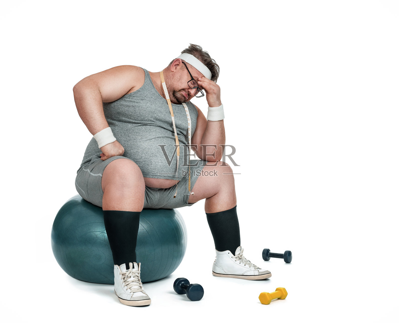 滑稽的肥胖运动员坐在健身球上照片摄影图片