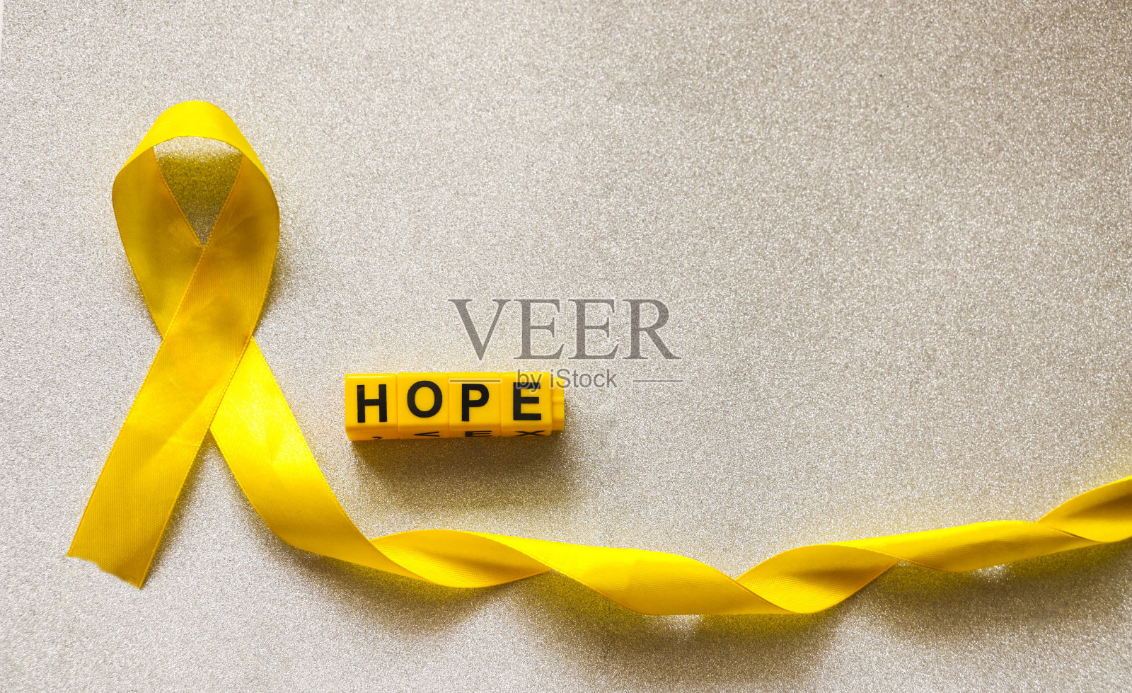 金色丝带和儿童塑料玩具。概念：儿童癌症的象征，儿科肿瘤学照片摄影图片