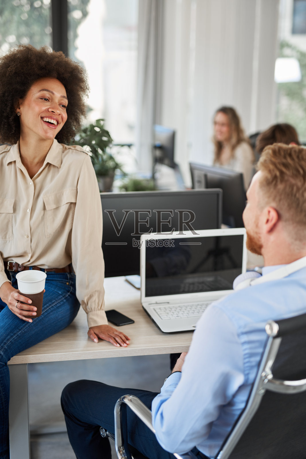 坐在办公室里的同事。照片摄影图片