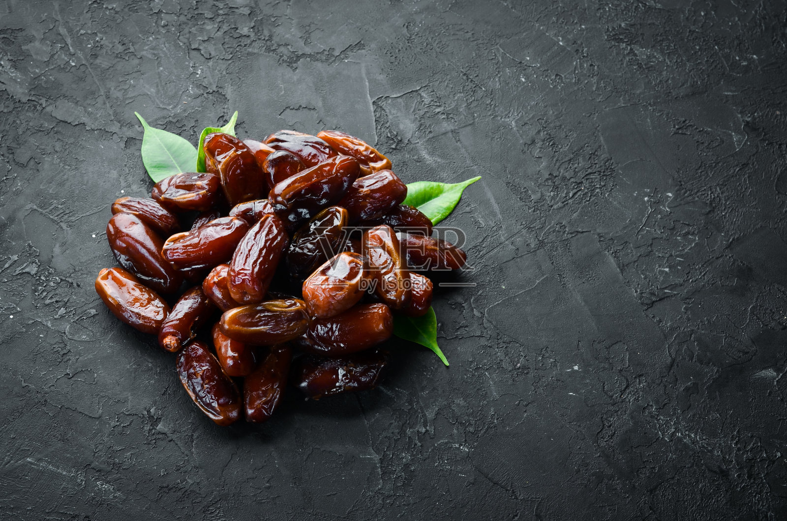 黑色背景上的干枣。前视图。为你的文本留出空间。照片摄影图片