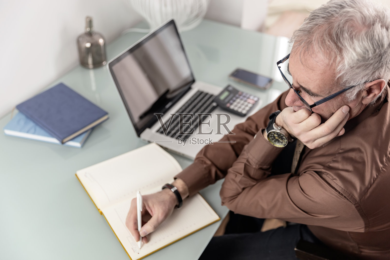 在办公室工作，系领带，穿棕色衬衫的中年男子。照片摄影图片