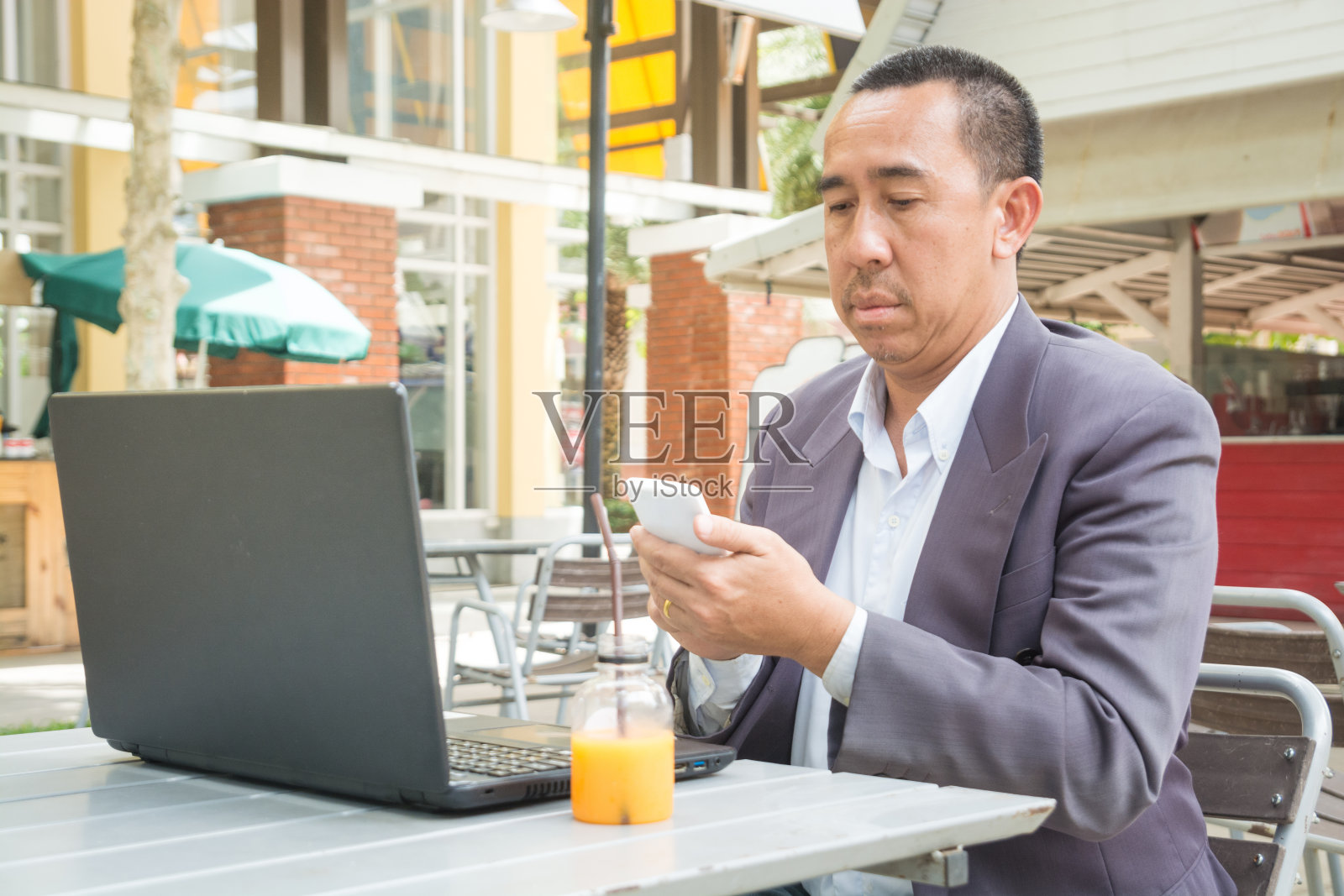 亚洲商人使用无线数字智能手机和笔记本电脑照片摄影图片