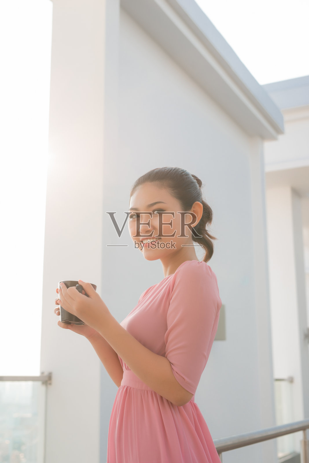 年轻女子拿着咖啡杯微笑着看着镜头照片摄影图片