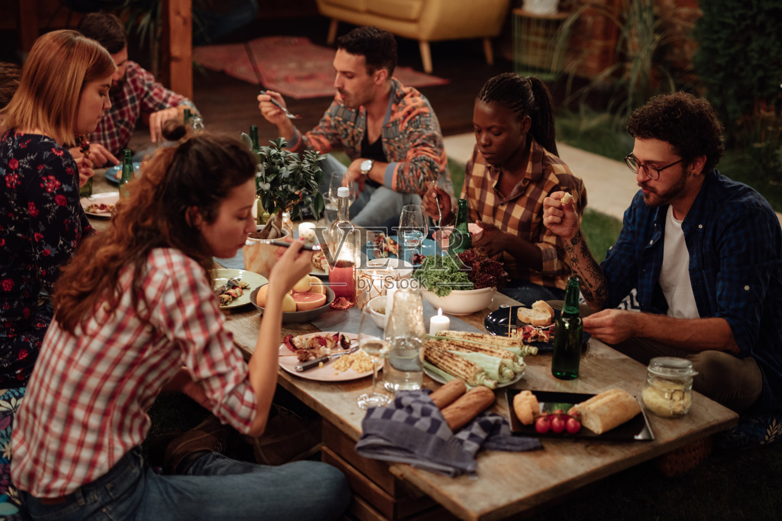 多民族朋友在院子里享用晚餐照片摄影图片