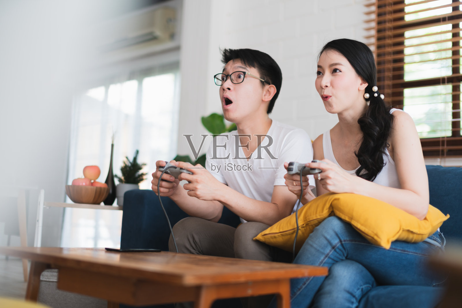 亚洲夫妻玩游戏，尽量赢得对方的家庭竞争观念照片摄影图片