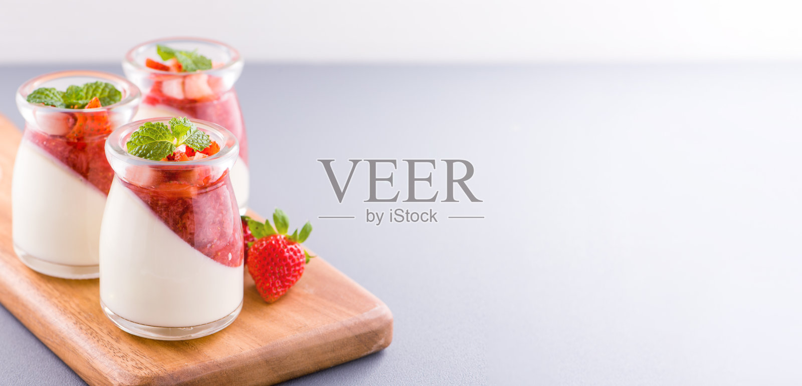 美味营养的双色草莓甜点与薄荷和肉果丁顶部孤立与通风的蓝色背景，复制空间，近距离照片摄影图片