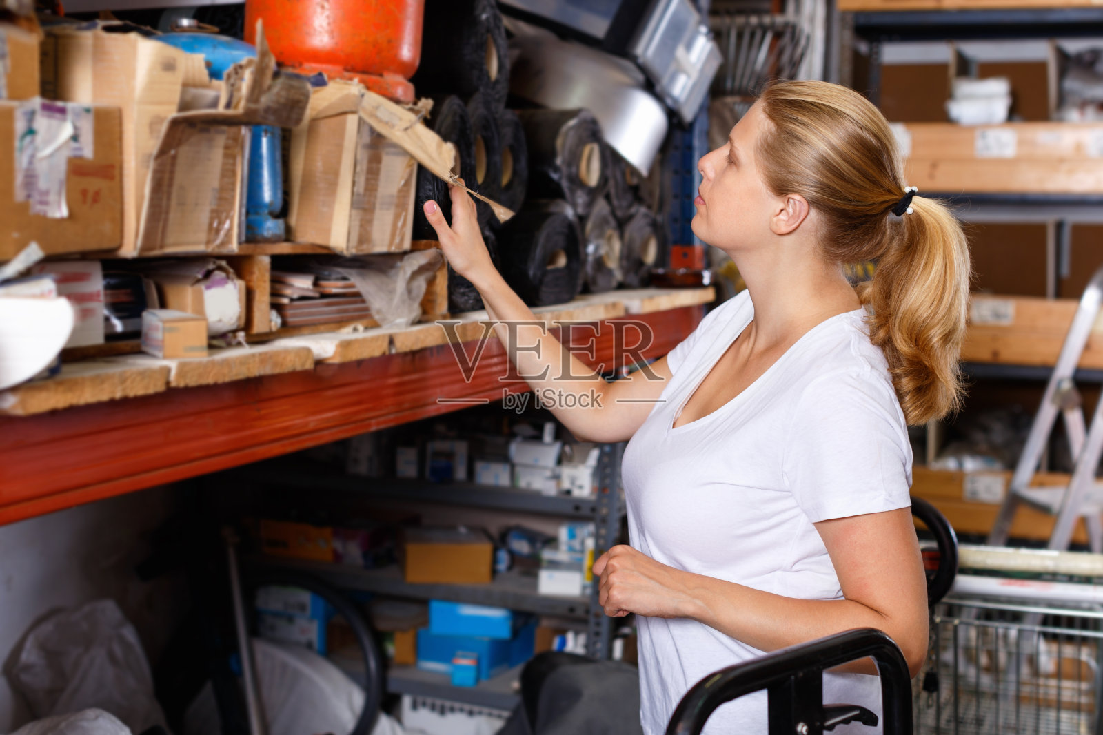 年轻女子在现代建筑商店的货架上挑选建筑材料照片摄影图片
