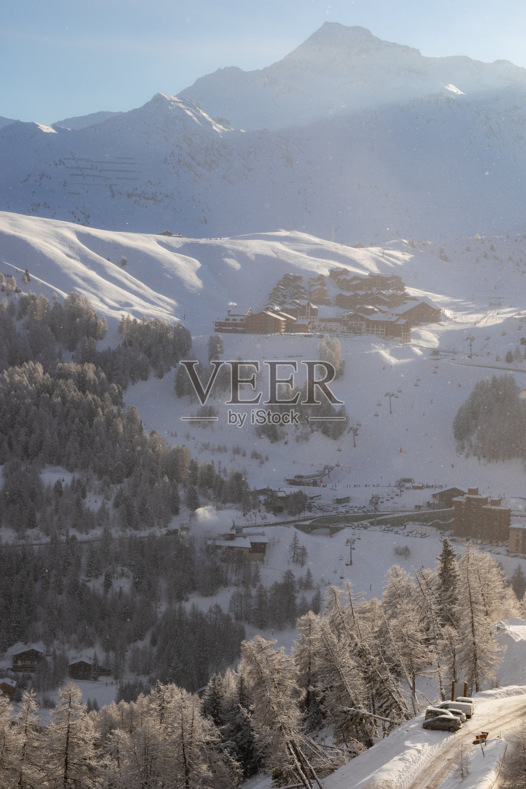 早晨在滑雪胜地拉普莱涅，法国阿尔卑斯山-普莱涅村与许多公寓和滑雪坡在阳光下轻雪。照片摄影图片