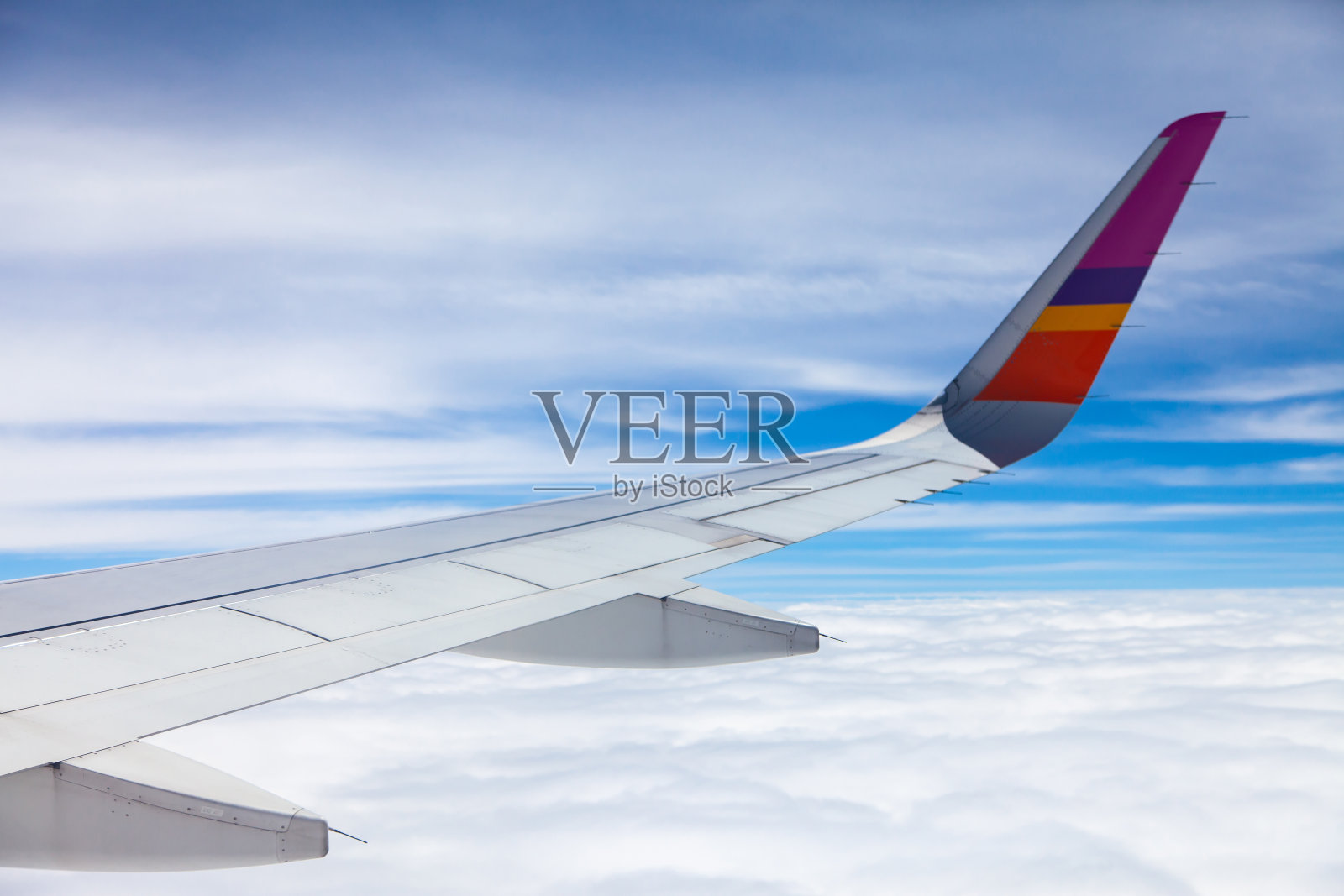 飞机机翼以蓝天和白云为背景。照片摄影图片