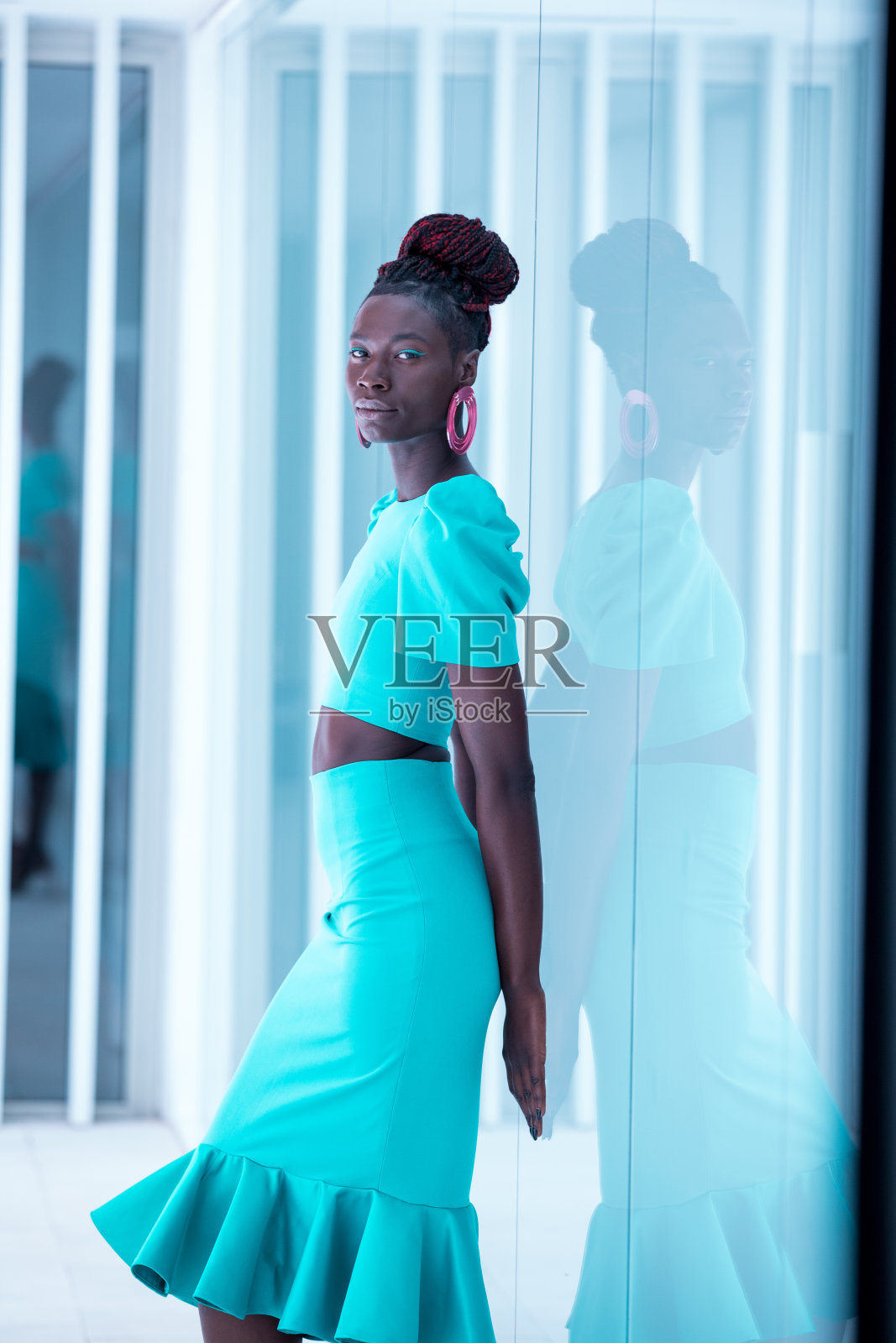 迷人的黑人女性穿着绿松石色的裙子走在t台上照片摄影图片
