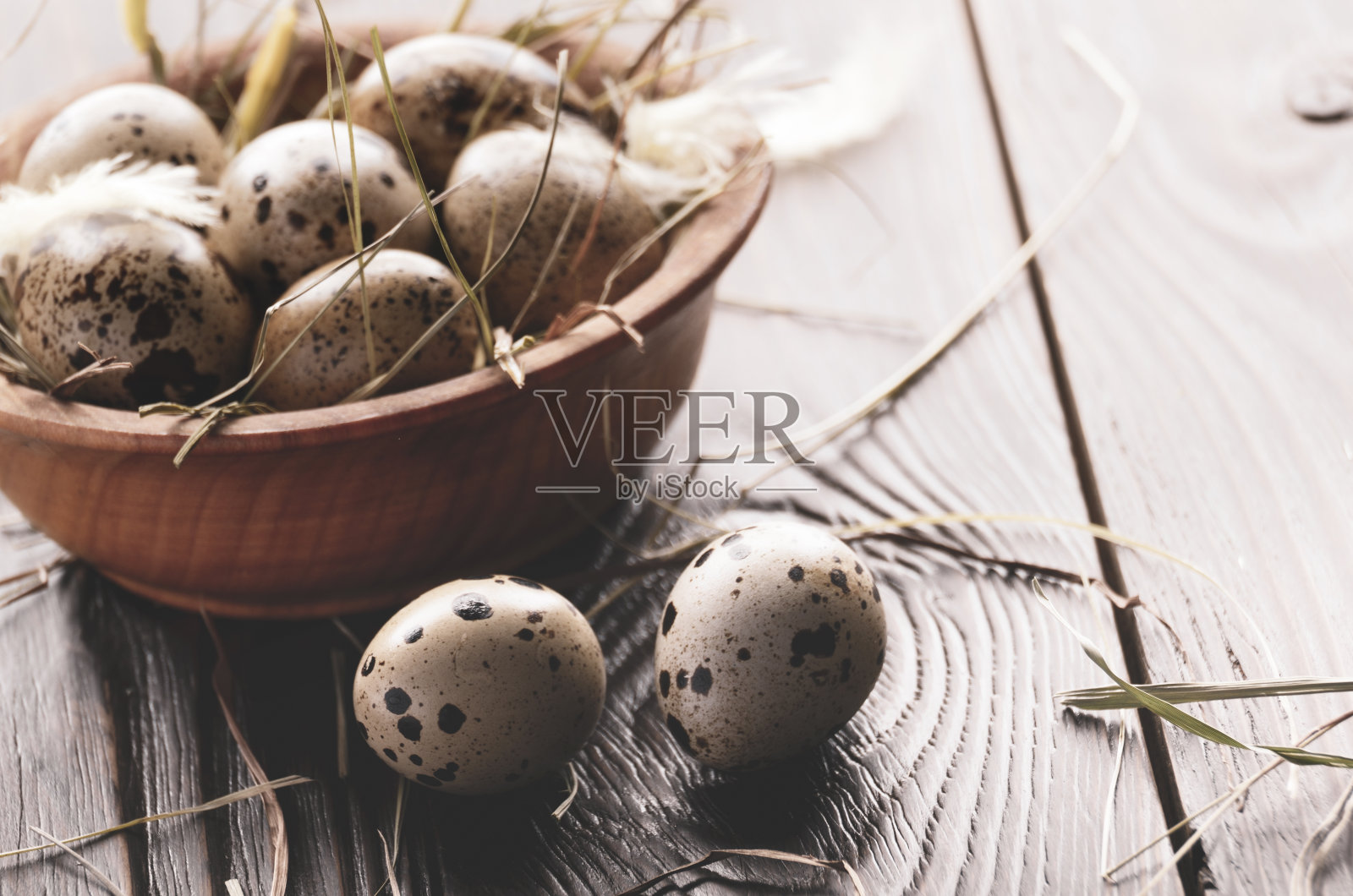 新鲜的有机鹌鹑蛋放在木碗里，放在质朴的餐桌上。空间的文本照片摄影图片