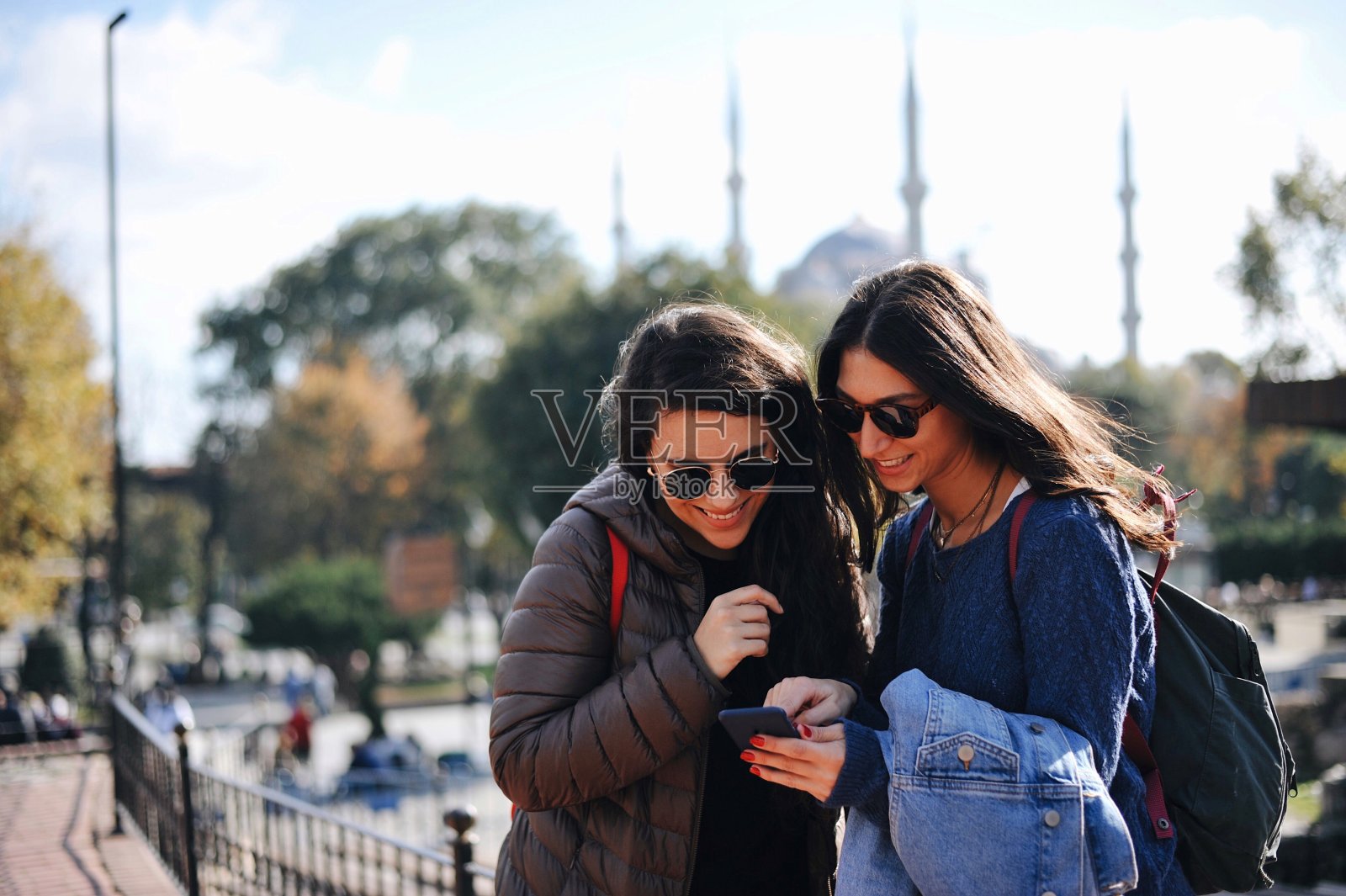 两个朋友在伊斯坦布尔的历史街区看手机照片摄影图片