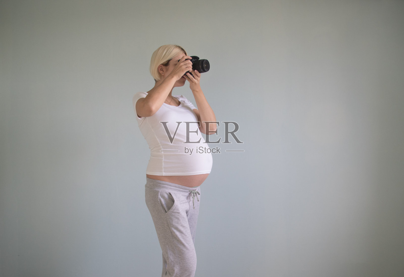 带着胶卷相机的孕妇摄影师照片摄影图片