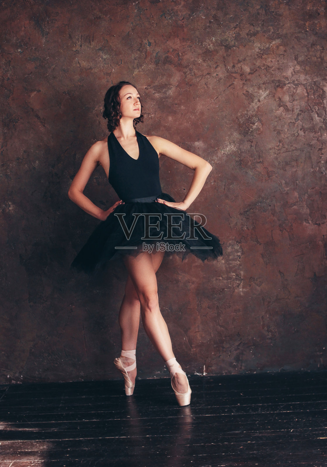 芭蕾舞女演员穿着漂亮的黑色短裙在阁楼工作室摆姿势照片摄影图片
