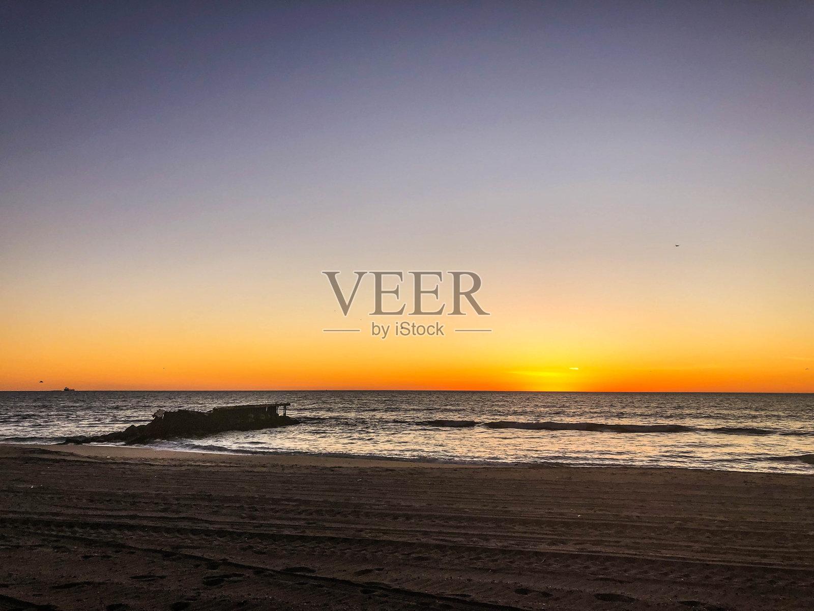 海浪冲击着在普拉亚德尔雷伊，加州的一个破碎的码头的岩石照片摄影图片