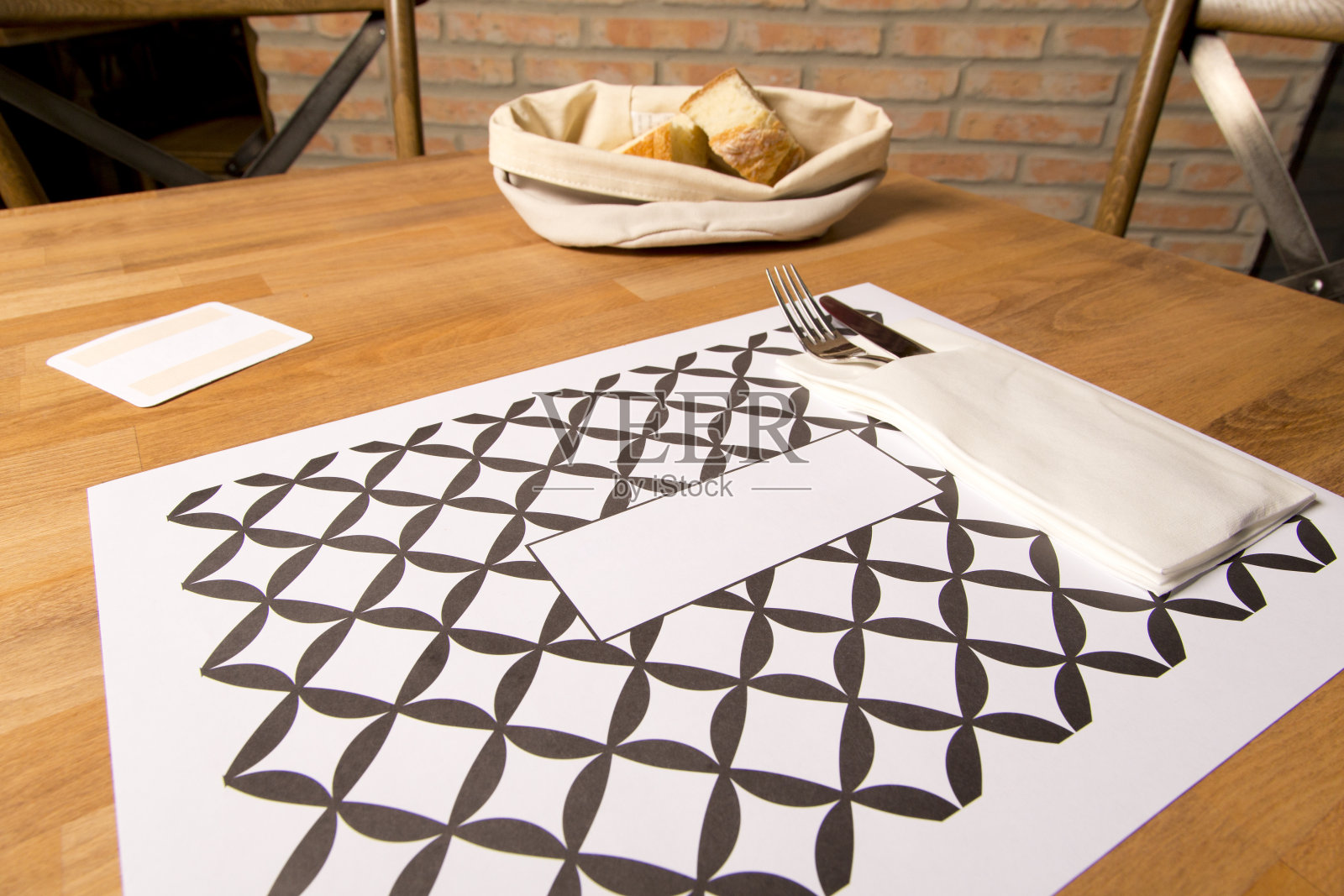 餐厅的木桌，有餐具、餐巾和面包照片摄影图片