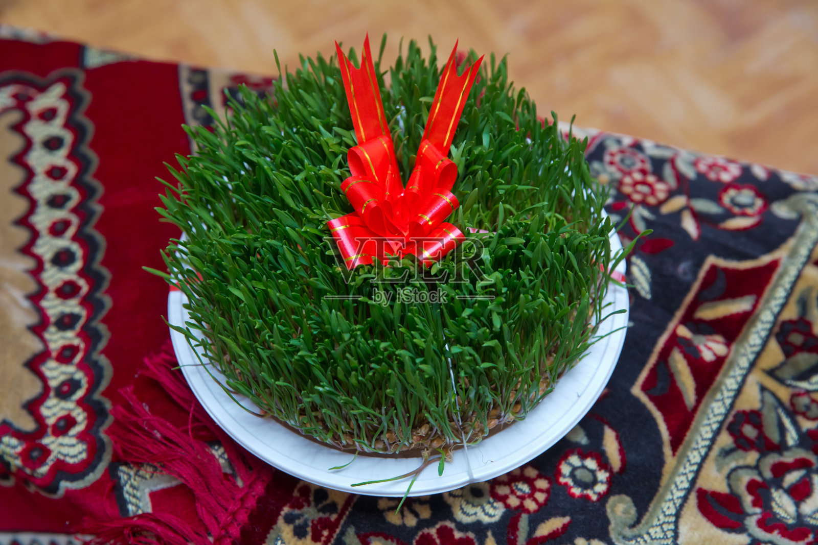 在干枯的草地上，红丝带上的种子地板。阿塞拜疆Novruz民族节日庆祝春天新年的概念，小麦草semeni。照片摄影图片