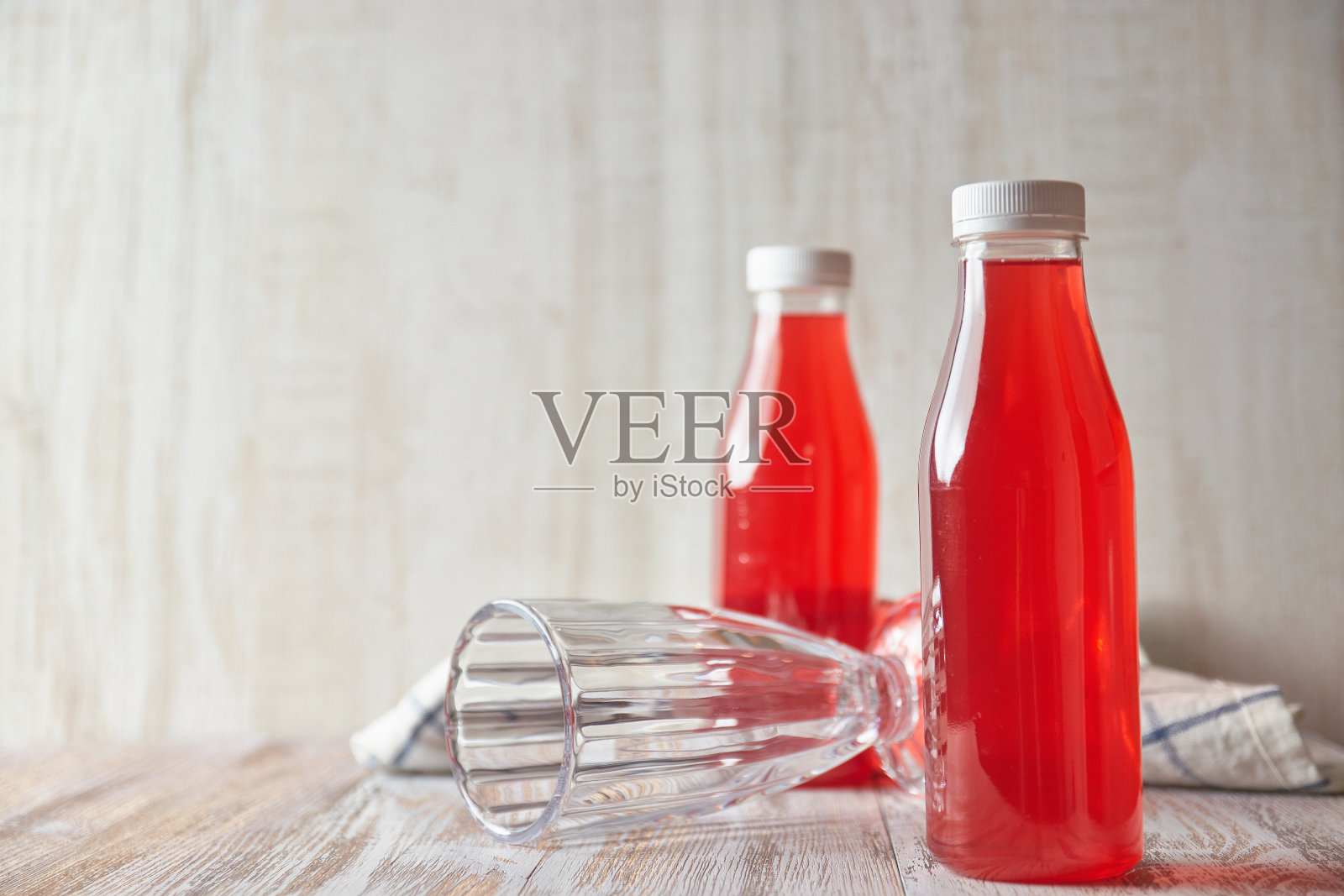 装瓶的莓汁放在轻木桌上。清爽的夏日饮品特写。照片摄影图片