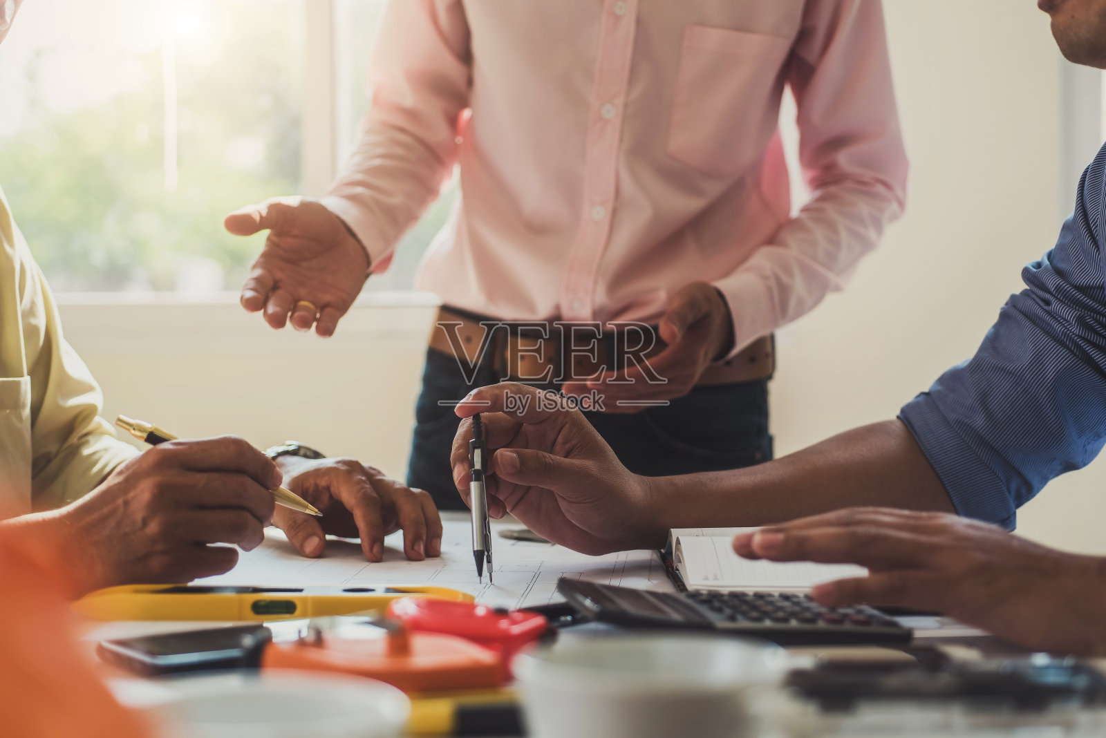 由专业建筑师组成的团队在设计室使用蓝图和工程工具进行建筑方案设计。建筑和结构概念。照片摄影图片