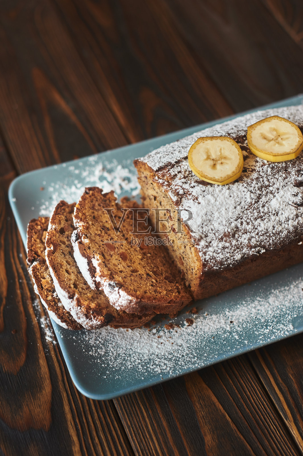 用糖粉和三根香蕉装饰的自制香蕉片蛋糕照片摄影图片