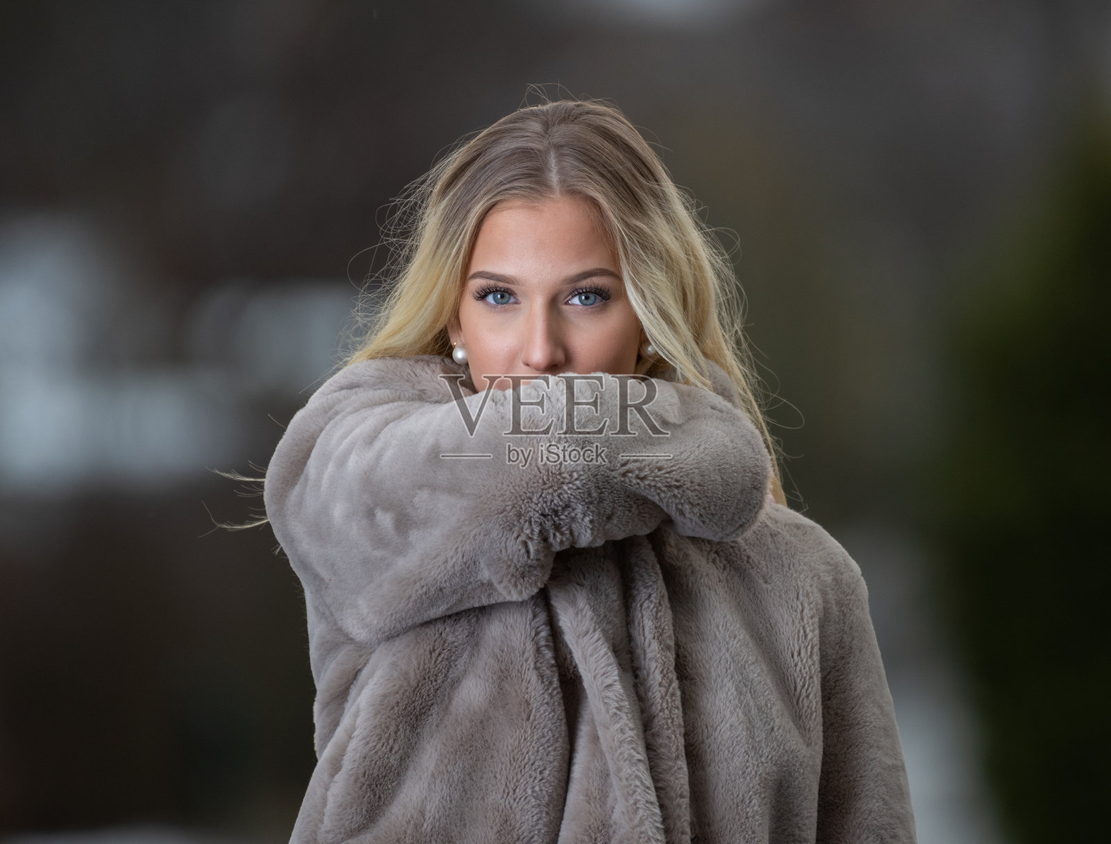 金发碧眼、面带微笑、穿着皮草的年轻女子照片摄影图片