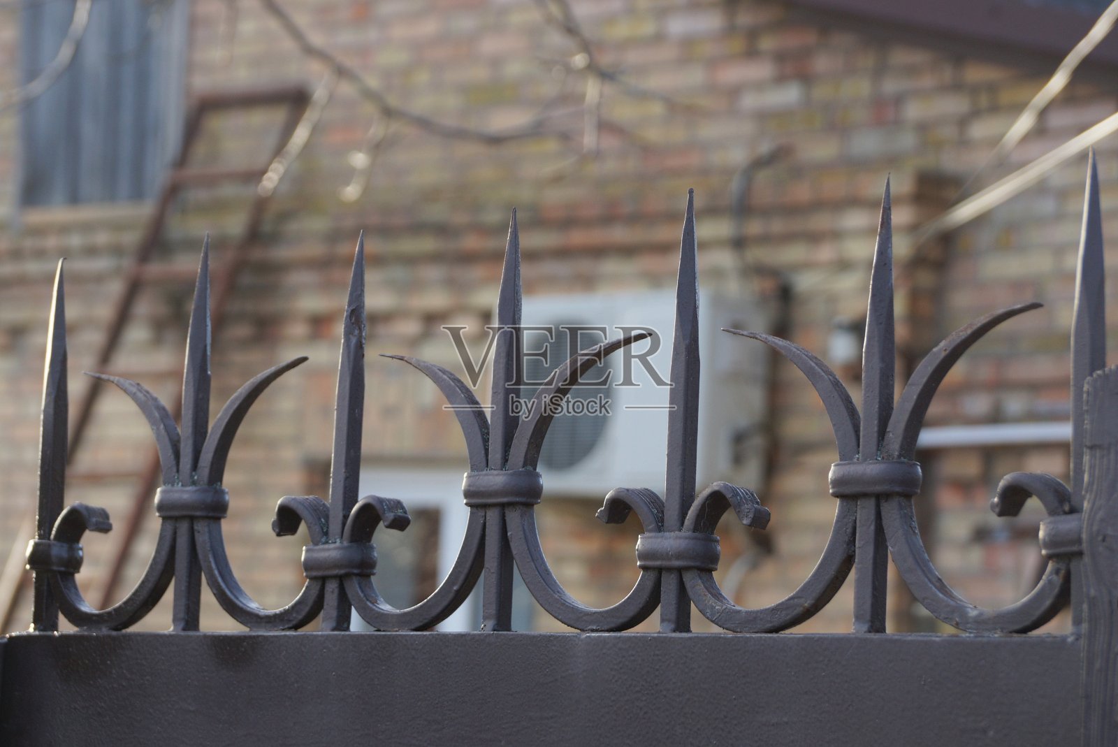 围栏的一部分由一系列锋利的棕色铁棒锻造而成照片摄影图片