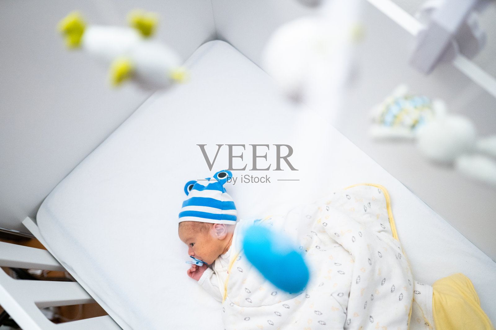 刚出生的男婴躺在婴儿床上照片摄影图片