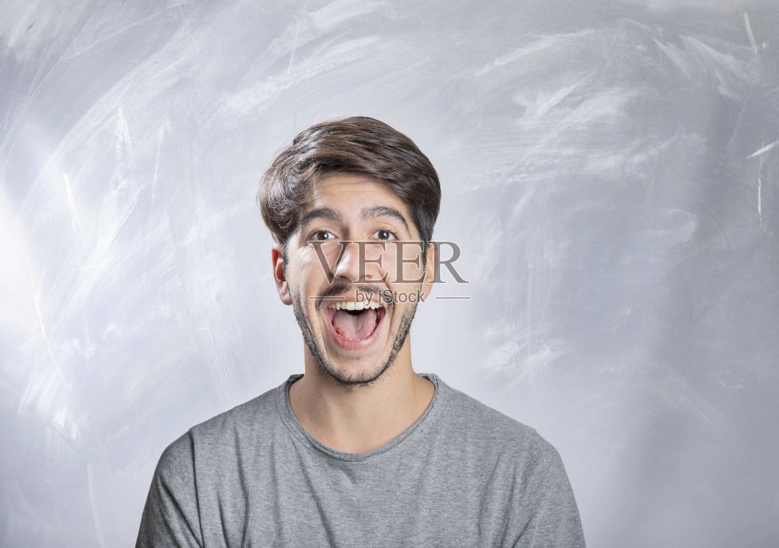 在工作室里微笑的年轻络腮胡男人肖像照片摄影图片