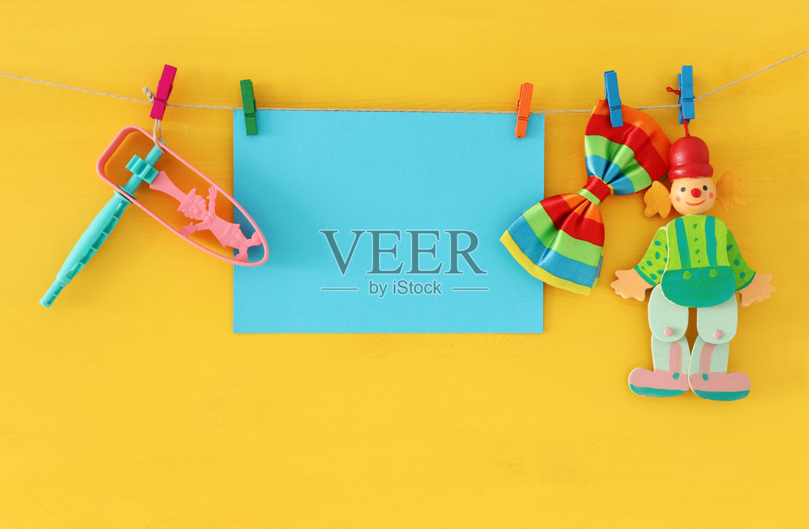 普林节庆祝概念(犹太狂欢节节日)与空白的文字，小丑和噪音制造者在木制黄色背景照片摄影图片