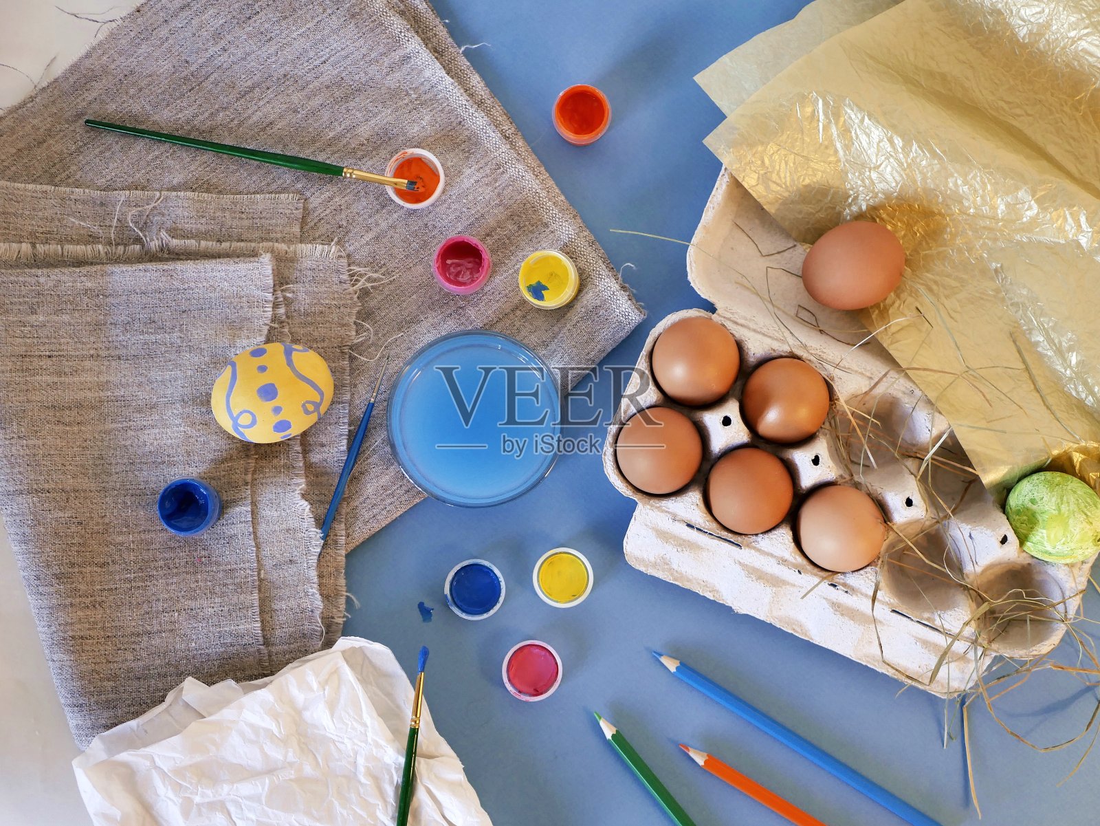 彩蛋，彩色的颜料，画笔，铅笔在蓝色的背景上，着色彩蛋，准备复活节照片摄影图片