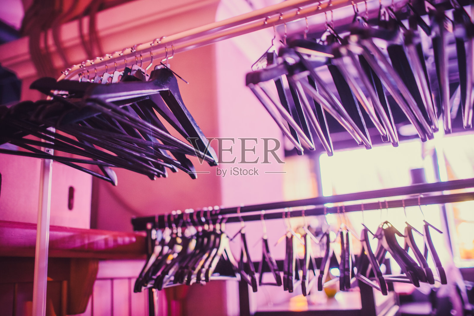 衣柜里的空衣架，酒店卧室衣柜里的衣架挂在衣架上。摘要为展示服装店清仓后的销售。照片摄影图片